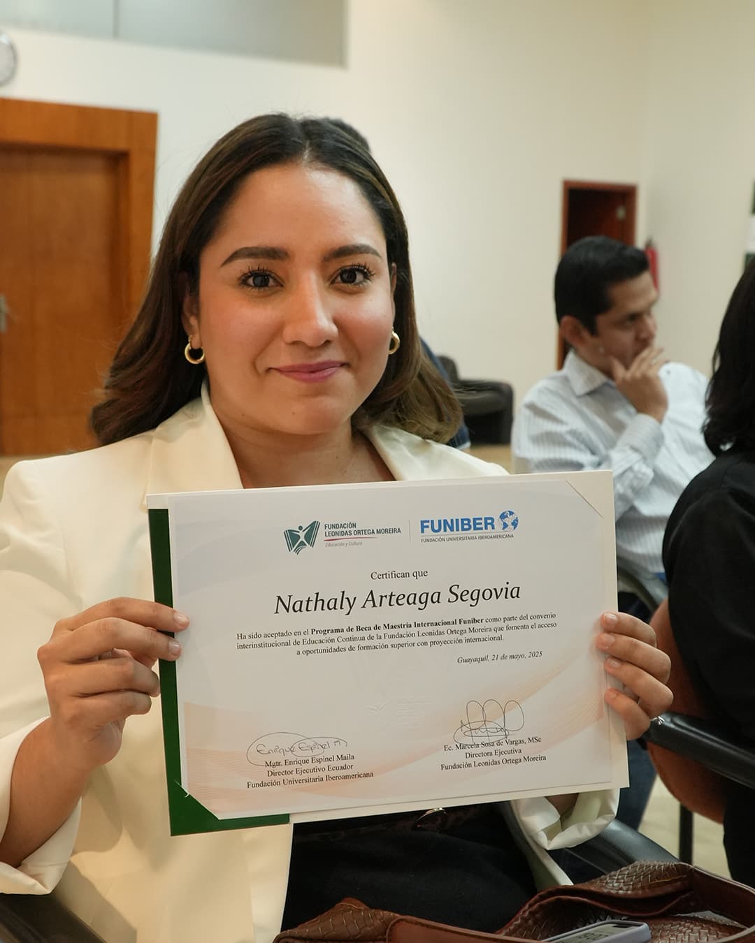 Becaria mostrando su certificado de maestría internacional FUNIBER
